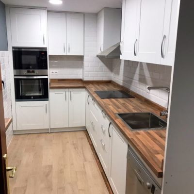 Muebles de cocina en blanco con encimera de madera