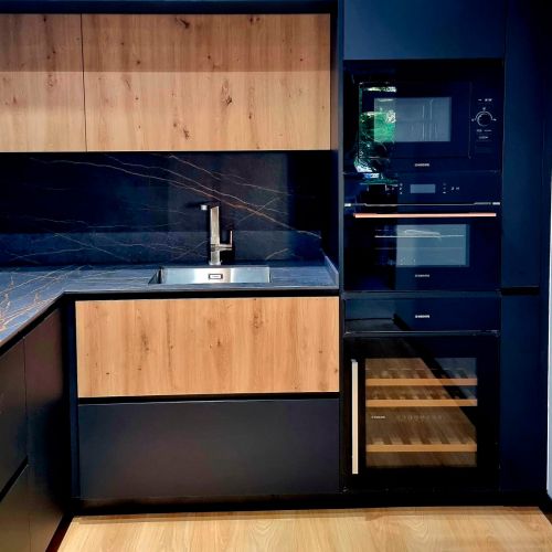 Muebles de cocina de madera de tono claro y encimera en tono oscuro