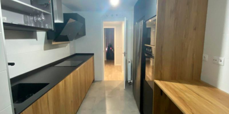 Cocina de madera con encimera de color oscuro