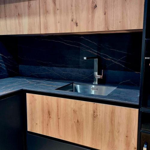 Muebles de cocina de madera en tono claro y encimera oscura