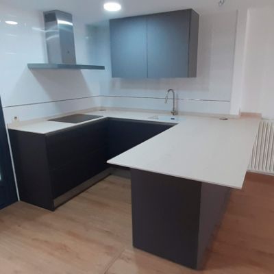 Muebles de cocina de madera oscura y encimera blanca