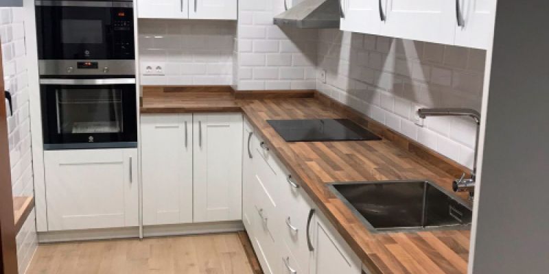 Muebles de cocina en blanco con encimera de madera